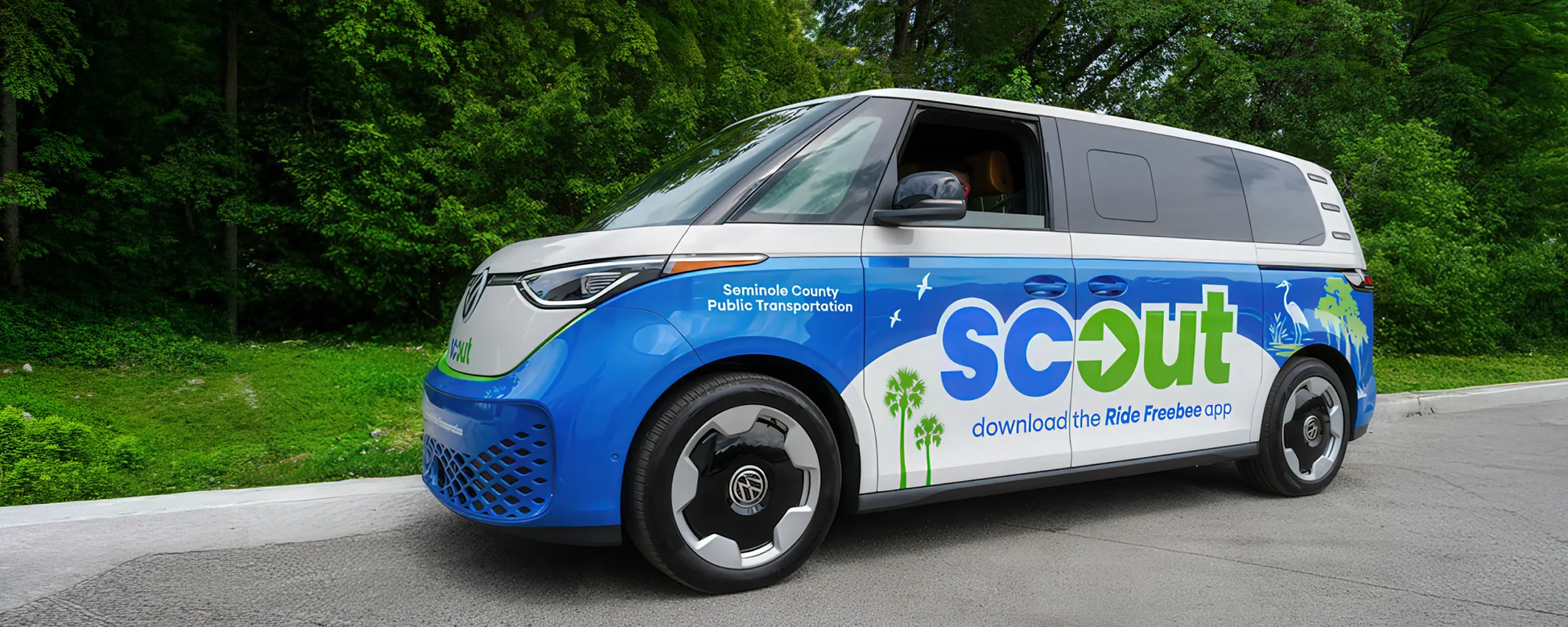 Masthead image - Freebee vehicle parked at Kissimmee/Amtrak station. Scout van parked at curb.