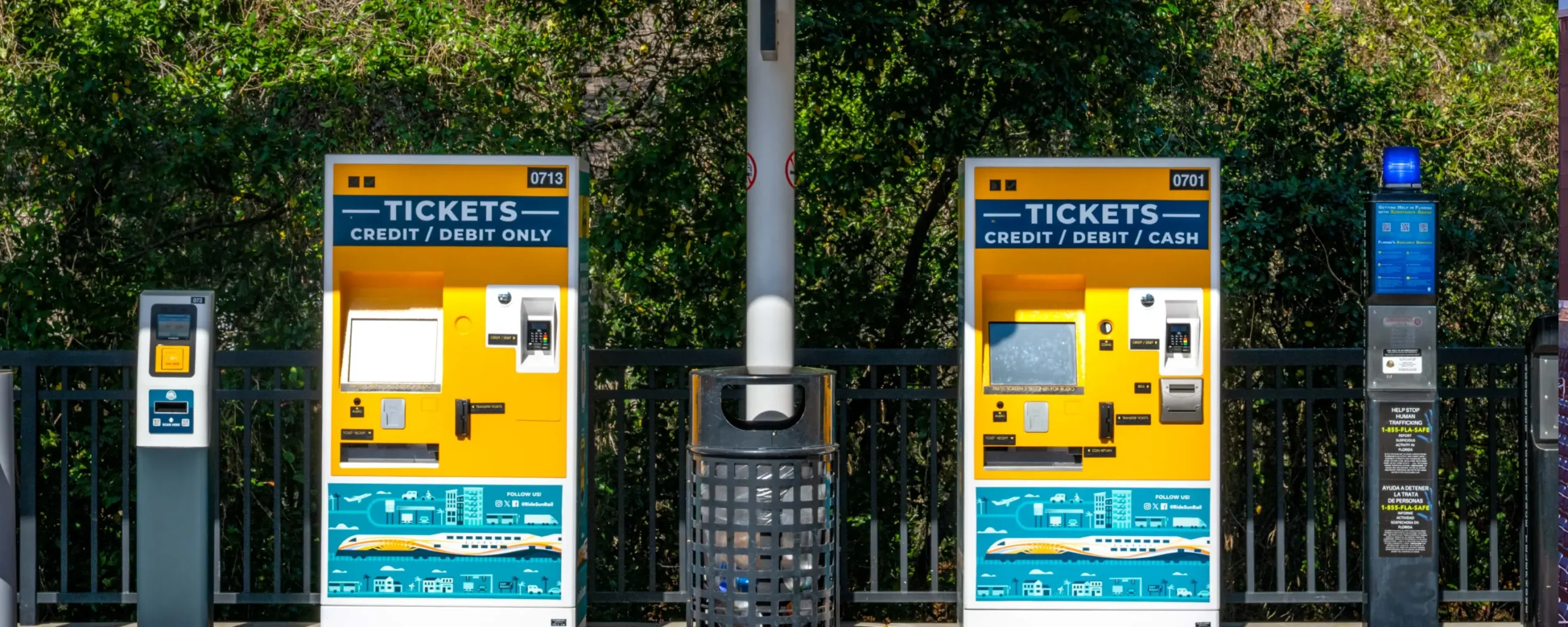 Imaj Masthead - platfòm estasyon ak machin lavant tikè. A ticket validator unit, two ticket vending machines, and an emergency call box at a SunRail station.