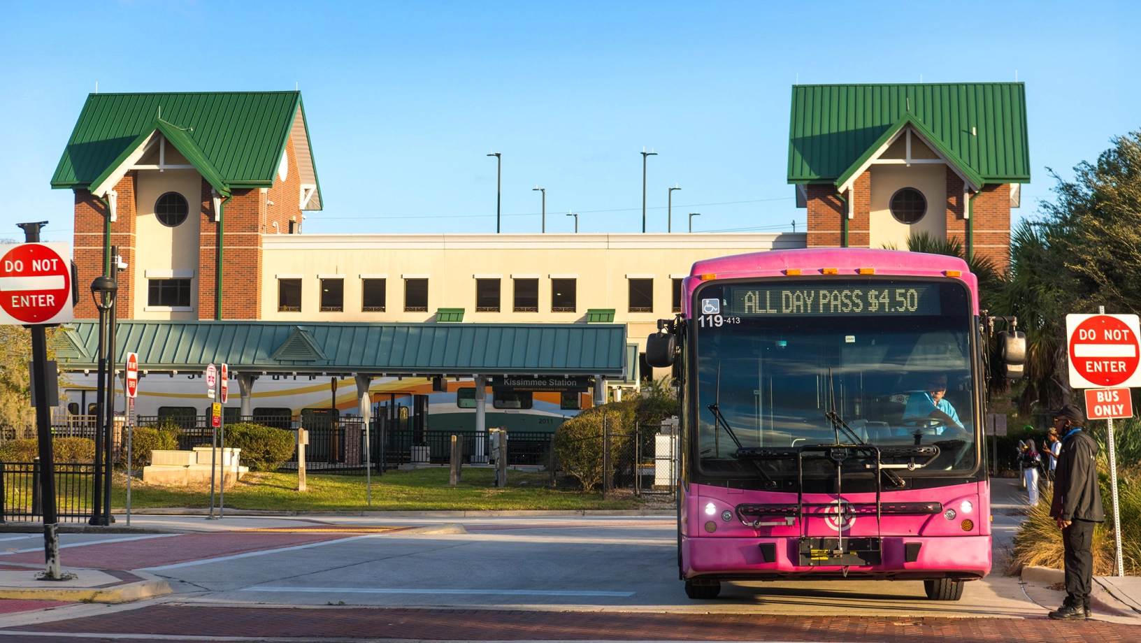 Exterior shot of SunRail Kissimmee/Amtrak, showing LYNX bus leaving station.