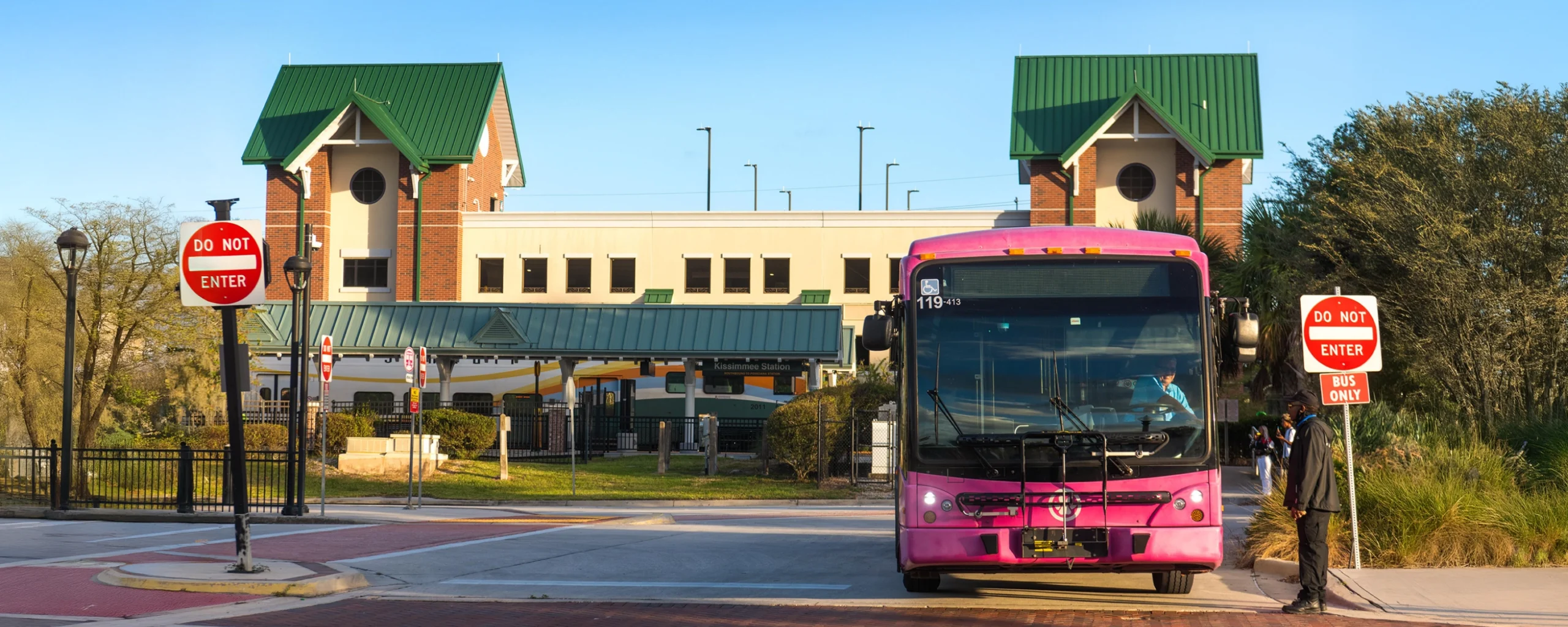 Exterior shot of SunRail Kissimmee/Amtrak, showing LYNX bus leaving station.