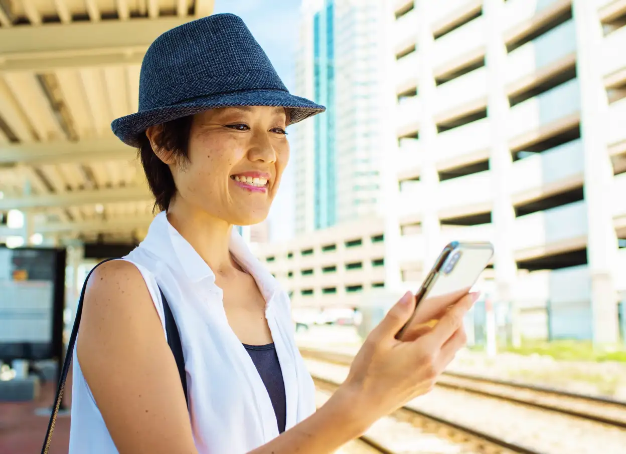 Woman on SunRail platform using her mobile device.
