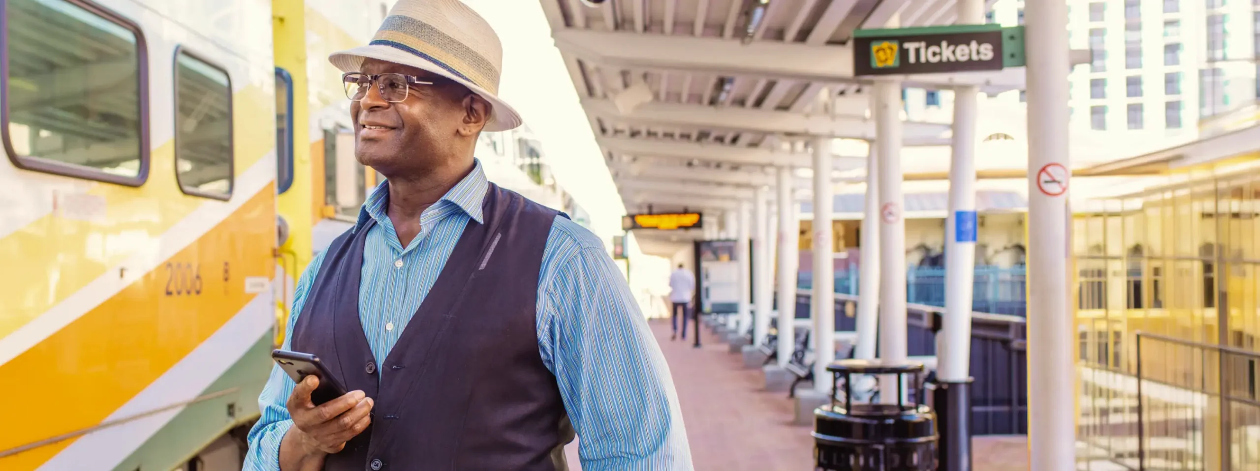 Gentleman waiting on SunRail platform using mobile phone.